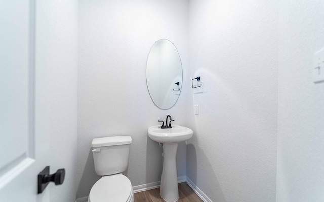 bathroom with wood-type flooring and toilet