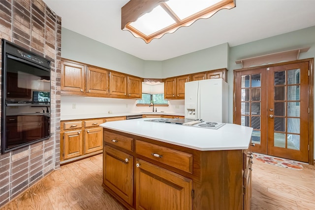 kitchen featuring white appliances, french doors, sink, light hardwood / wood-style flooring, and a kitchen island