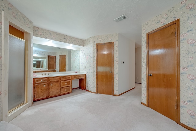 bathroom featuring vanity and a shower with door