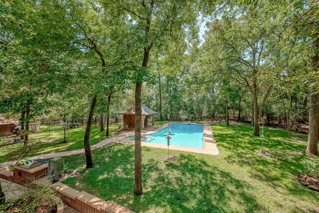 view of swimming pool with a lawn and an outbuilding