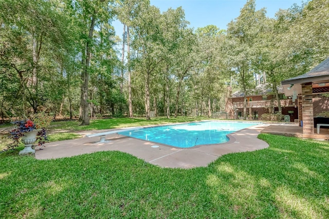 pool featuring a yard, a diving board, and a patio area