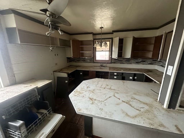 kitchen featuring dark wood-type flooring, ceiling fan with notable chandelier, backsplash, and sink