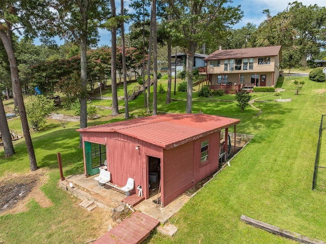 exterior space featuring a yard, an outbuilding, and metal roof