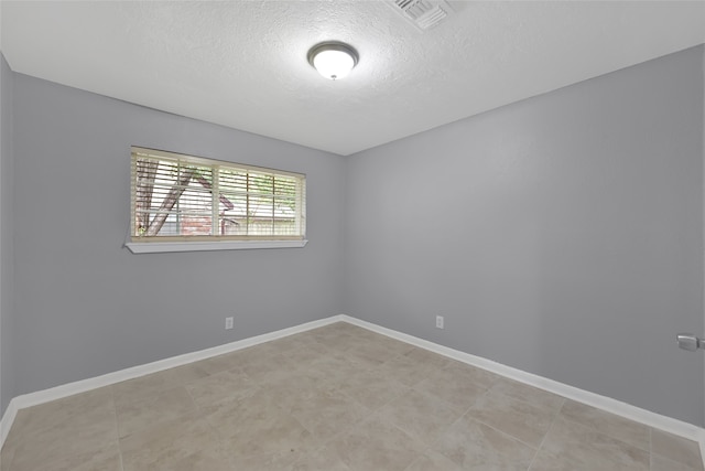 unfurnished room featuring a textured ceiling