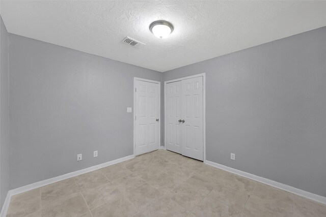 unfurnished room featuring a textured ceiling