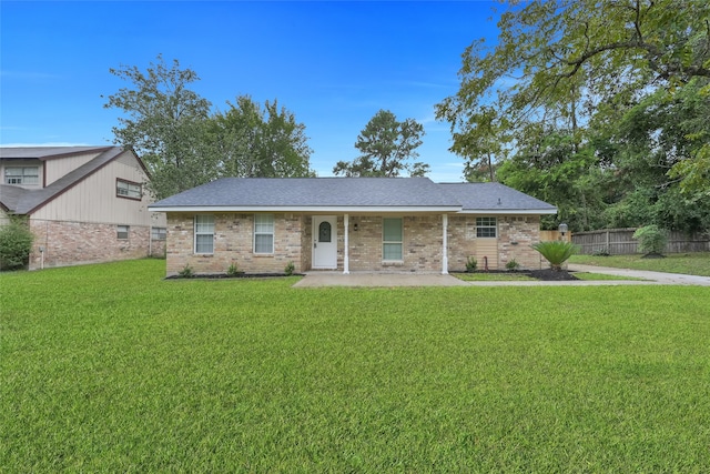 ranch-style home with a front lawn and a patio