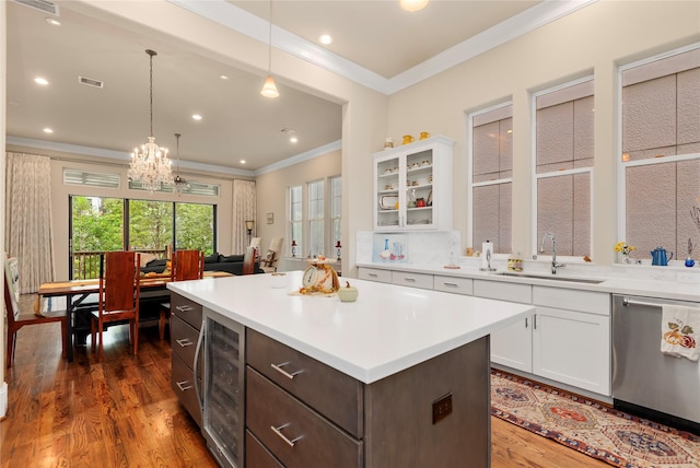 kitchen featuring dark wood finished floors, stainless steel dishwasher, white cabinets, a sink, and beverage cooler