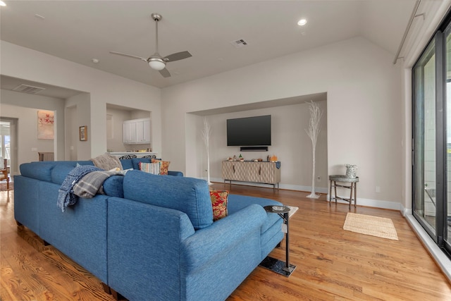 living room featuring plenty of natural light, visible vents, and light wood-type flooring