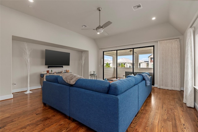 living area featuring visible vents, vaulted ceiling, a ceiling fan, and wood finished floors