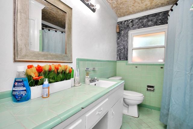 bathroom with vanity, tile patterned flooring, crown molding, toilet, and tile walls