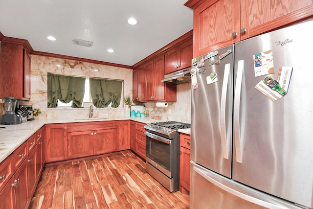 kitchen featuring ornamental molding, light hardwood / wood-style flooring, light stone counters, sink, and appliances with stainless steel finishes