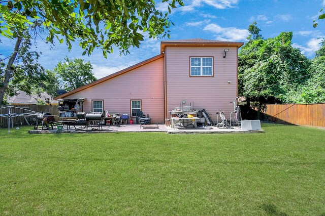 back of property with a lawn and a patio