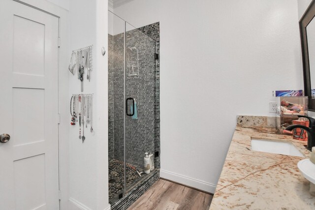 bathroom featuring vanity, toilet, hardwood / wood-style flooring, and a shower with shower door