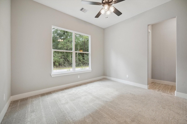 carpeted spare room featuring ceiling fan