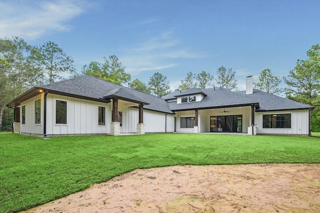 rear view of house featuring a lawn