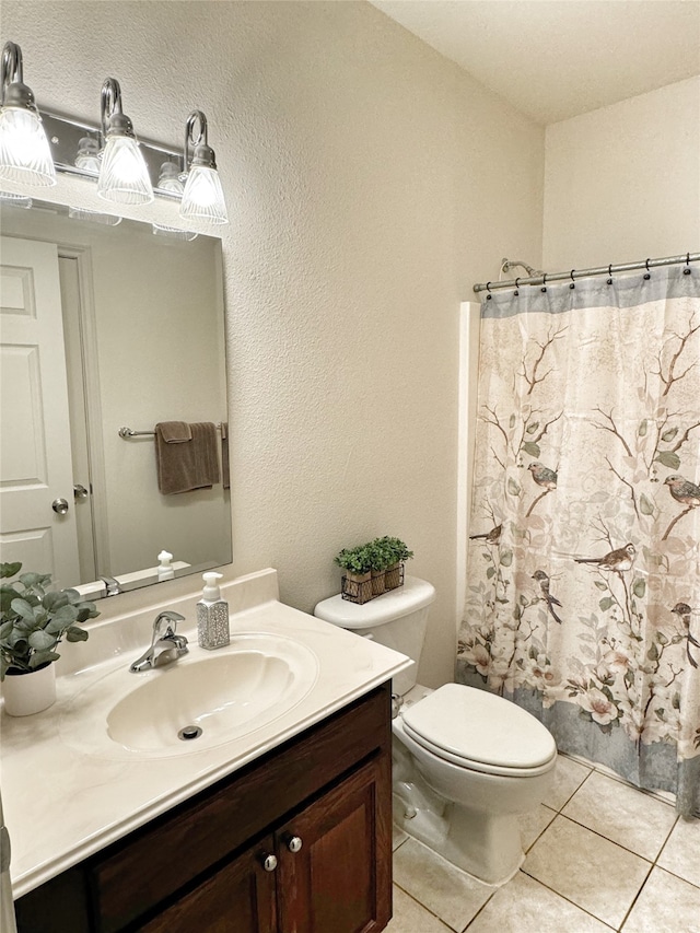 bathroom featuring tile patterned floors, toilet, curtained shower, and vanity