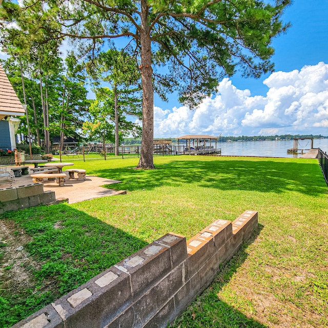 view of yard featuring a water view, a patio area, an outdoor fire pit, and a dock