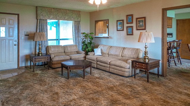 carpeted living room featuring a textured ceiling and ceiling fan