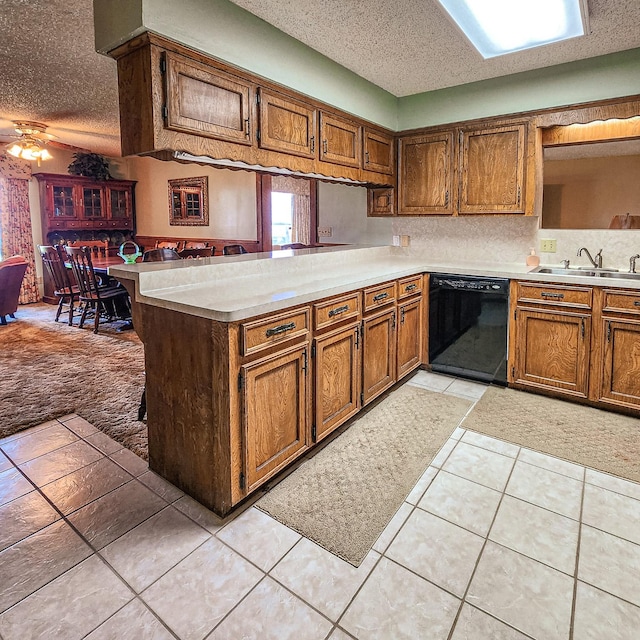 387 Indian Hl, Livingston, TX 77351 - kitchen featuring a peninsula, a textured ceiling, a sink, and black dishwasher