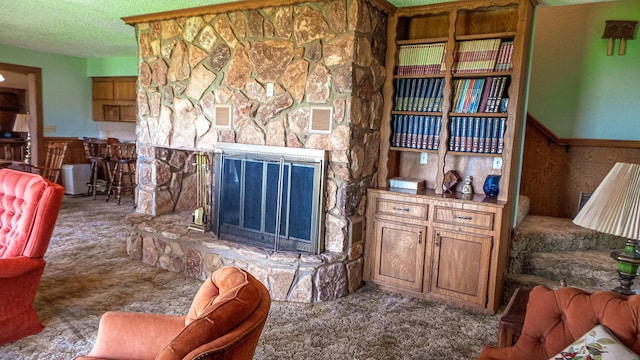 carpeted living room with a textured ceiling and a fireplace