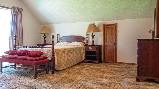 bedroom with carpet, a textured ceiling, and lofted ceiling