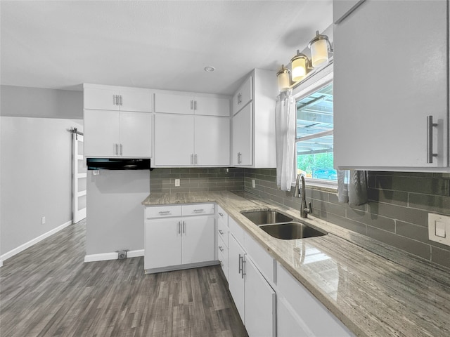 kitchen featuring dark hardwood / wood-style flooring, backsplash, sink, and white cabinets