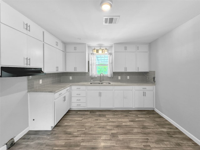 kitchen with dark wood-type flooring, backsplash, and white cabinets