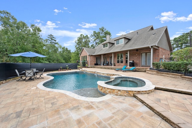 view of swimming pool with an in ground hot tub and a patio