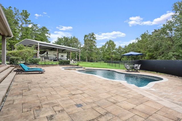 view of swimming pool featuring a patio, an in ground hot tub, and a lawn