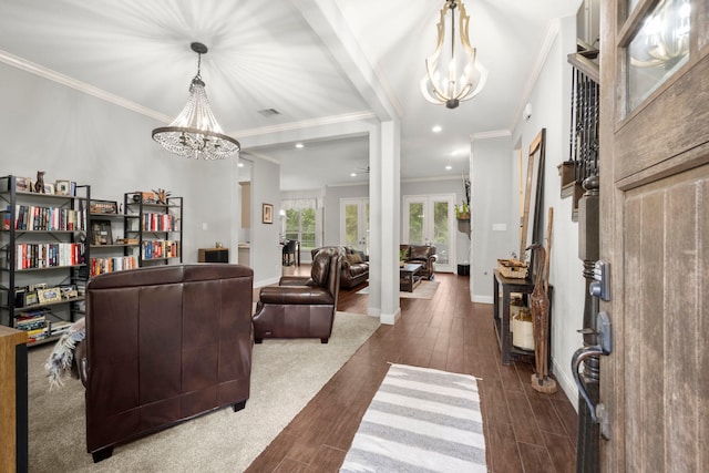 living room featuring dark hardwood / wood-style flooring, a notable chandelier, and crown molding