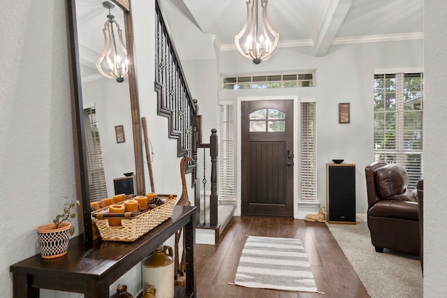 entrance foyer featuring ornamental molding, dark hardwood / wood-style floors, a notable chandelier, and beam ceiling