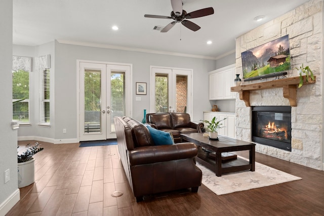 living room featuring a fireplace, crown molding, ceiling fan, french doors, and dark hardwood / wood-style floors