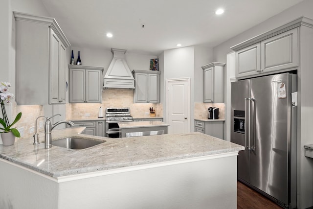 kitchen with gray cabinetry, stainless steel appliances, sink, and custom exhaust hood