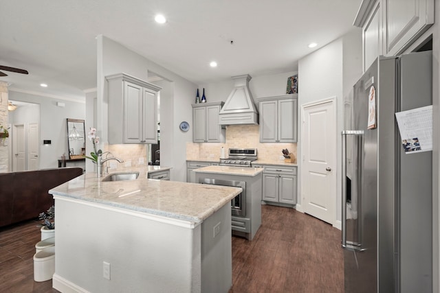 kitchen with gray cabinets, dark wood-type flooring, kitchen peninsula, custom range hood, and stainless steel appliances