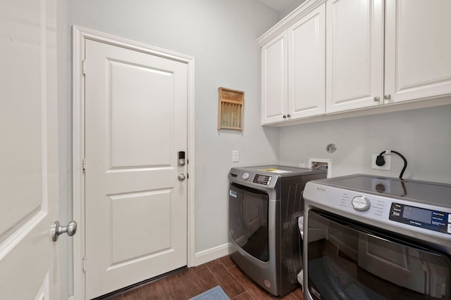 clothes washing area featuring cabinets, separate washer and dryer, and dark hardwood / wood-style flooring