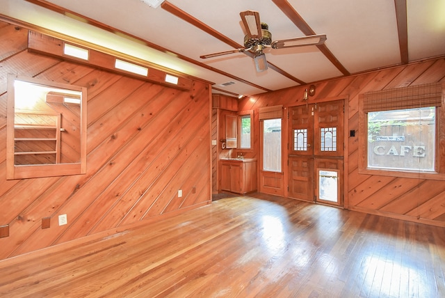 foyer featuring wood walls, ceiling fan, and hardwood / wood-style flooring