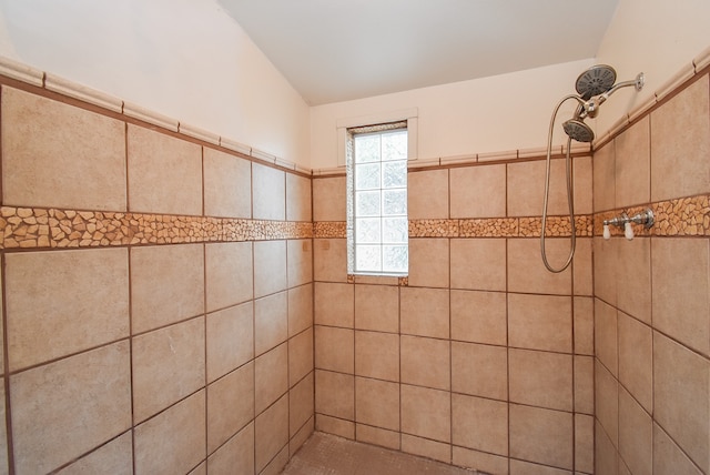 bathroom with lofted ceiling and a tile shower