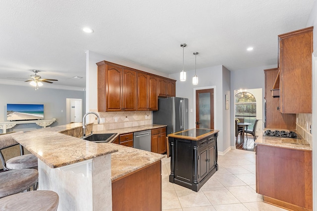 kitchen featuring pendant lighting, sink, decorative backsplash, kitchen peninsula, and light stone countertops