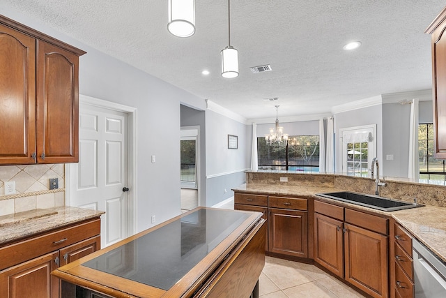 kitchen with pendant lighting, dishwasher, sink, and light tile patterned floors