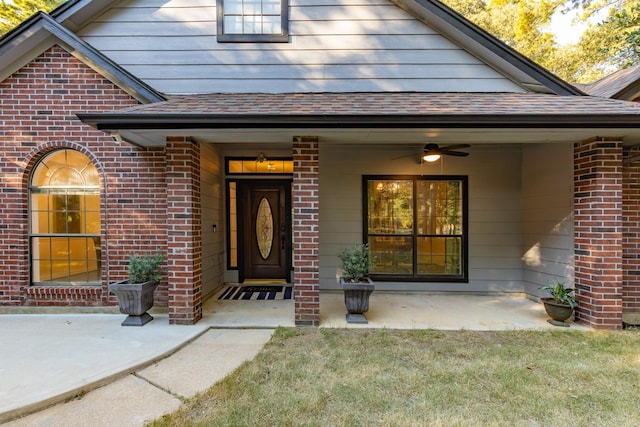 property entrance with ceiling fan and a lawn