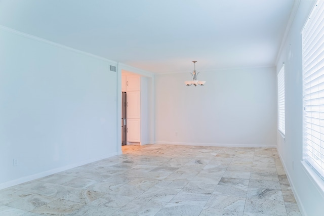 empty room with crown molding and a notable chandelier