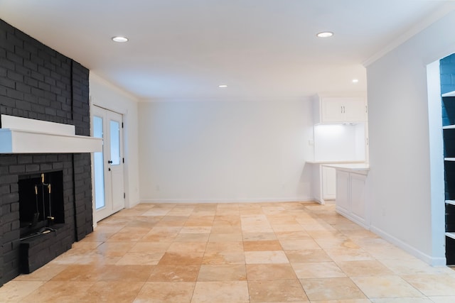 unfurnished living room with crown molding and a brick fireplace