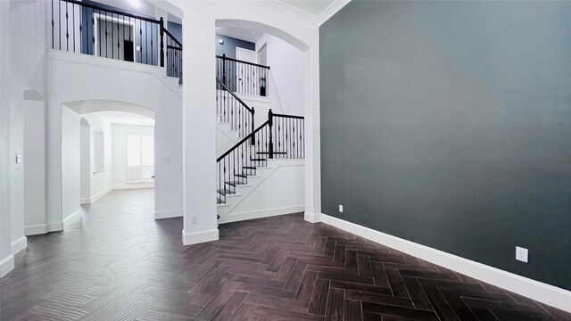 stairs featuring a high ceiling, parquet flooring, and crown molding