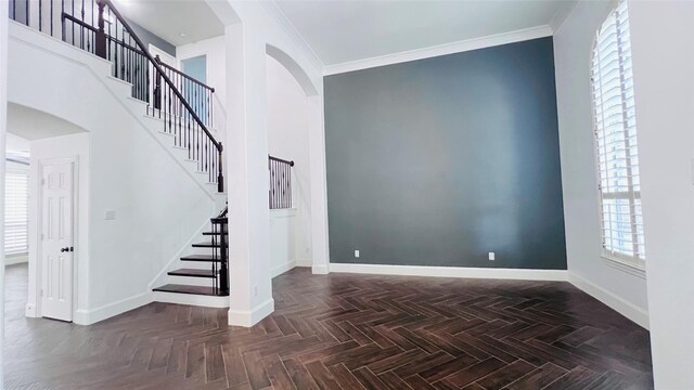 foyer entrance featuring dark parquet floors and ornamental molding