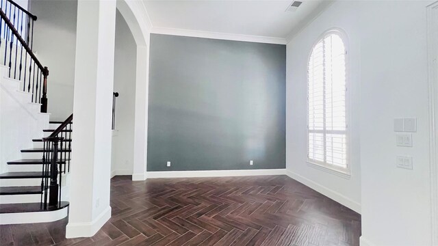 unfurnished room with dark parquet floors, plenty of natural light, and ornamental molding