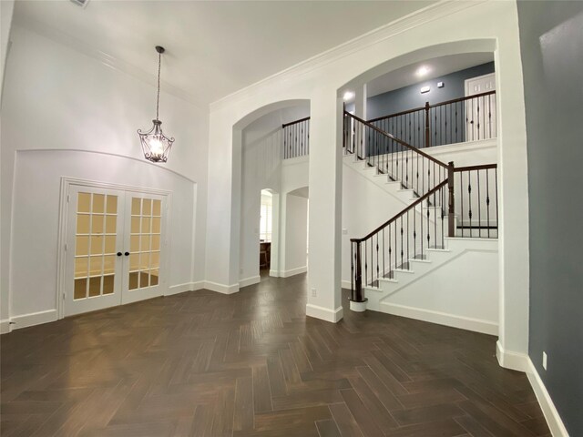 interior space featuring crown molding, french doors, and dark parquet floors