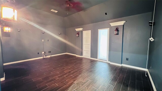 spare room featuring vaulted ceiling, ceiling fan, and dark hardwood / wood-style floors