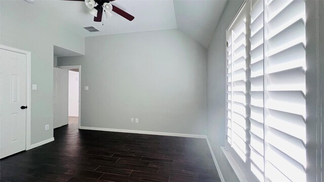 spare room featuring dark wood-type flooring, vaulted ceiling, and ceiling fan