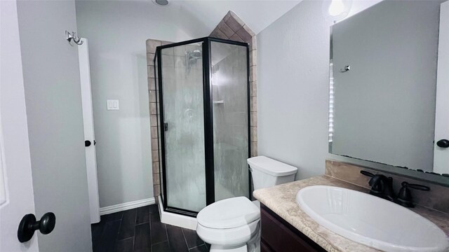 bathroom featuring a shower with shower door, vaulted ceiling, toilet, and vanity