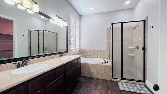 bathroom with vanity, wood-type flooring, and independent shower and bath